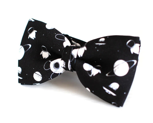 Pajarita negra con estampado de planetas y astronautas blancos, diseño friki original para hombre y niño