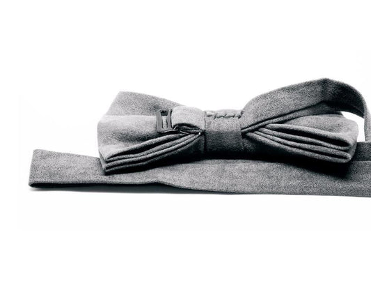 Pajarita gris de tela con diseño elegante y hebilla ajustable sobre fondo blanco