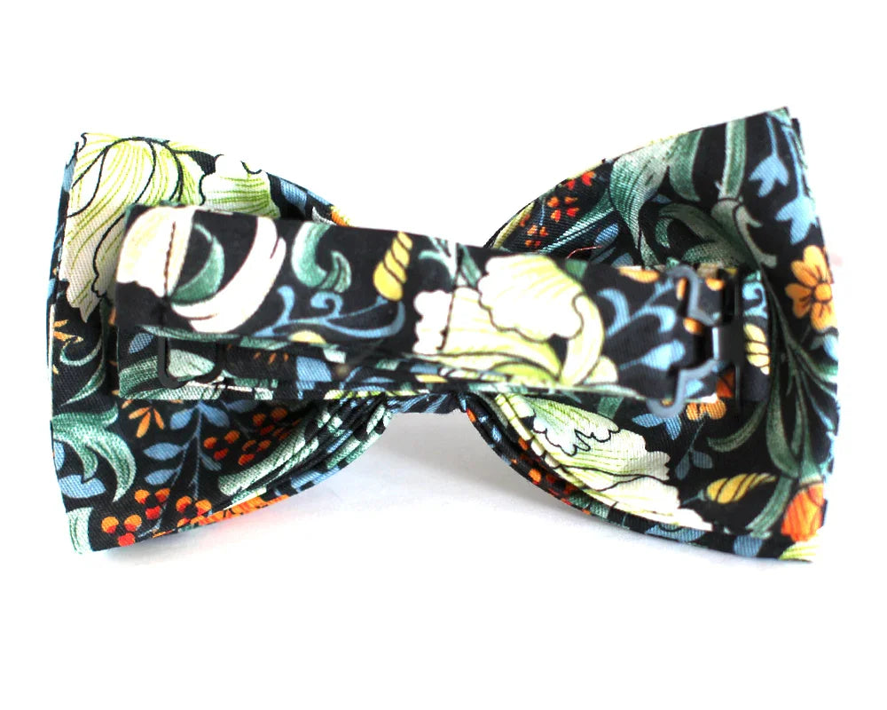 Pajarita original con estampado de hojas y flores verdes, amarillas y naranja sobre fondo negro