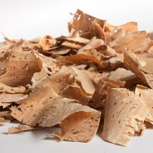 Virutas de corcho natural en primer plano sobre fondo blanco para pajaritas y complementos artesanales