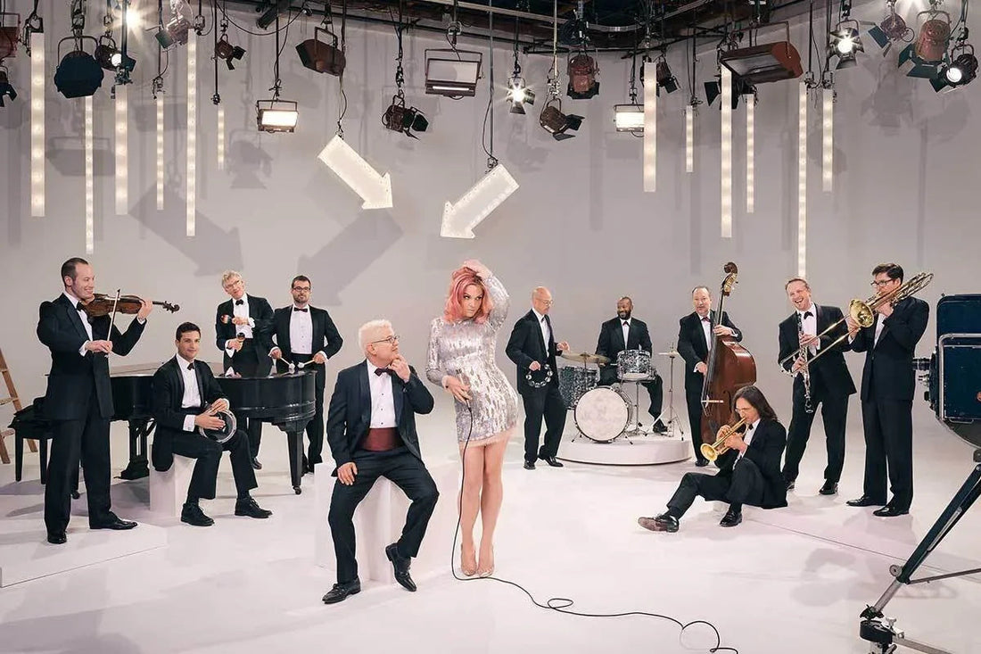 Banda musical con traje formal y cantante mujer en vestido plateado actuando en estudio con flechas luminosas