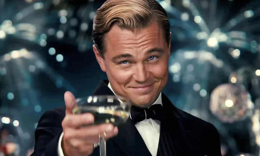 Hombre elegante con pajarita negra brindando con copa de champán en fiesta con luces de fondo