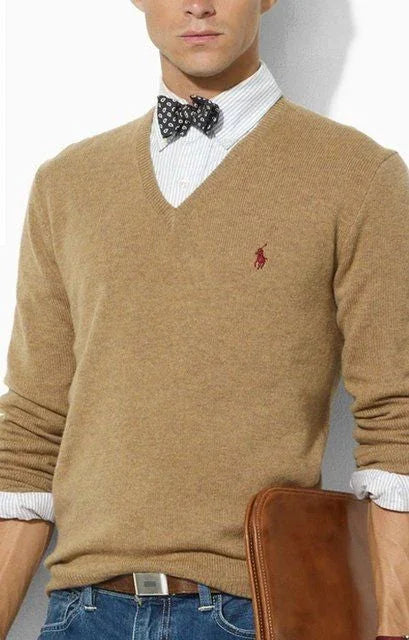 Hombre con pajarita original negra con estampado blanco, camisa blanca y jersey marrón claro