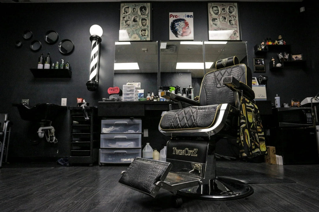 Silla de barbero negra con detalles acolchados y decoración oscura en barbería moderna